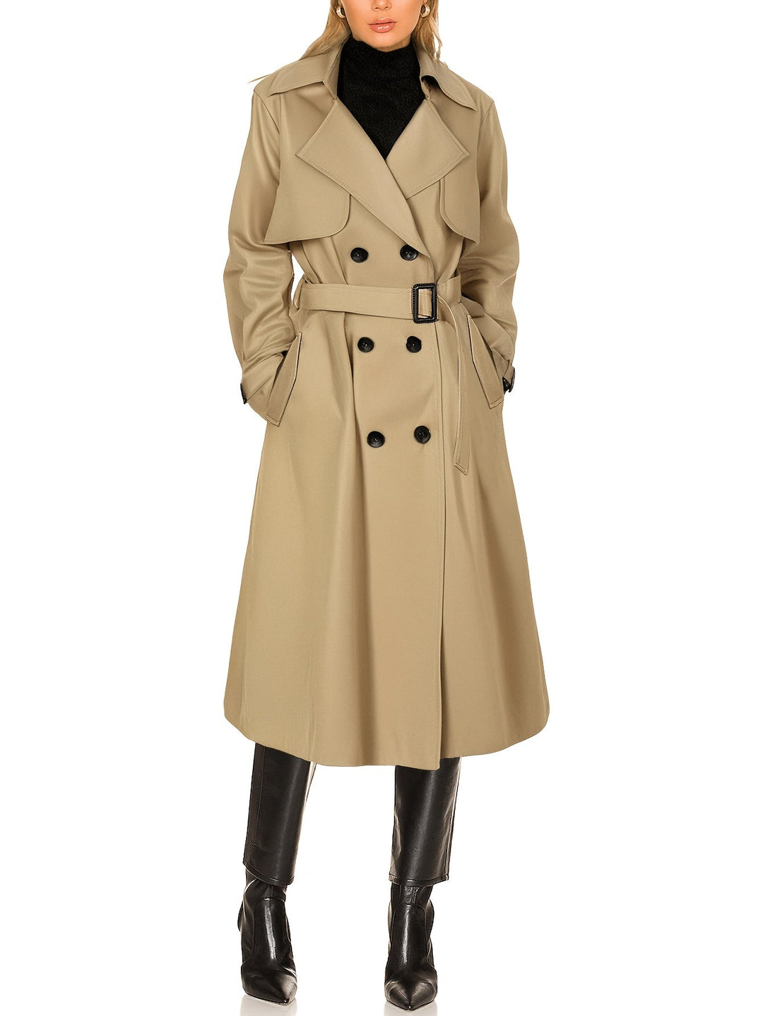 Kvinna i lång beige dubbelknäppt trenchcoat med knytbälte och svarta boots