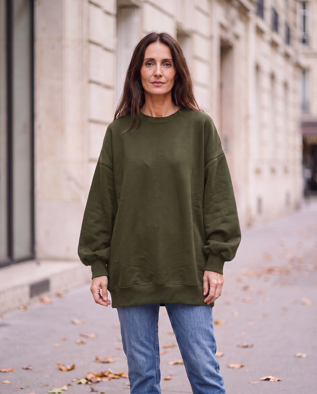 Kvinna i grön oversized sweatshirt utan sidöppningar, framifrån