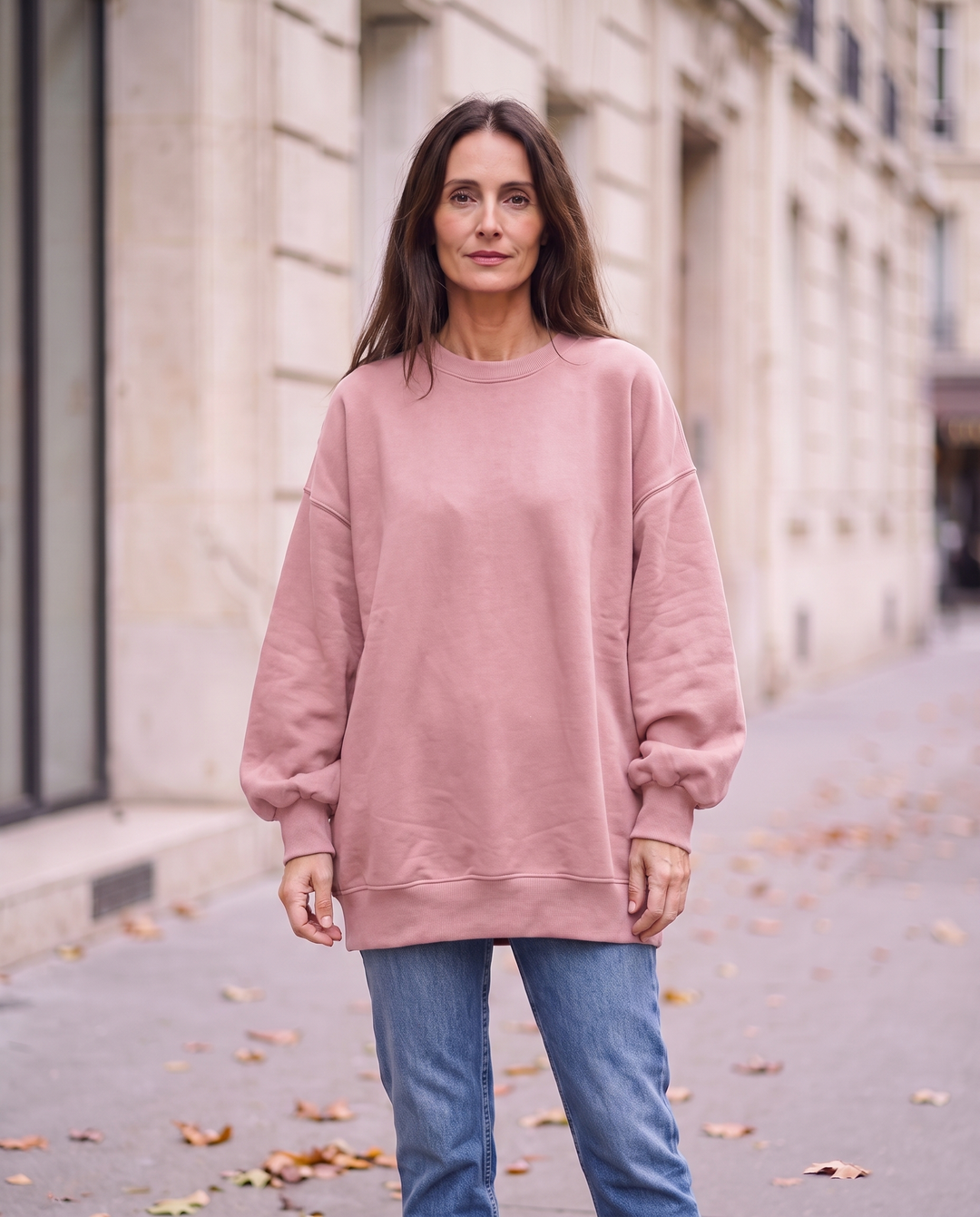 Kvinna i rosa oversized sweatshirt utan sidöppningar, framifrån