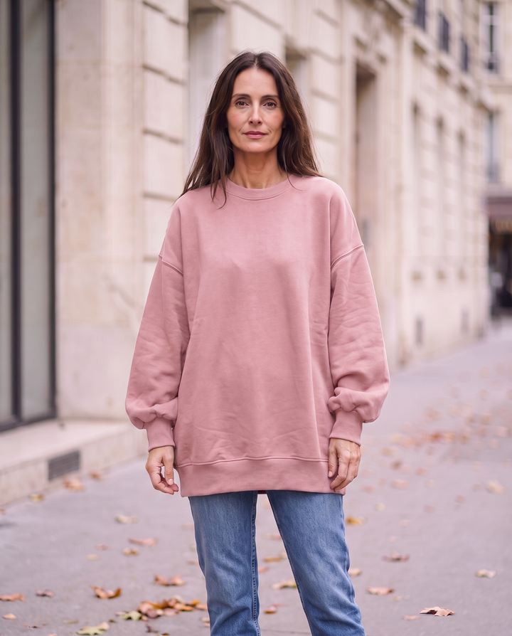 Kvinna i rosa oversized sweatshirt utan sidöppningar, framifrån
