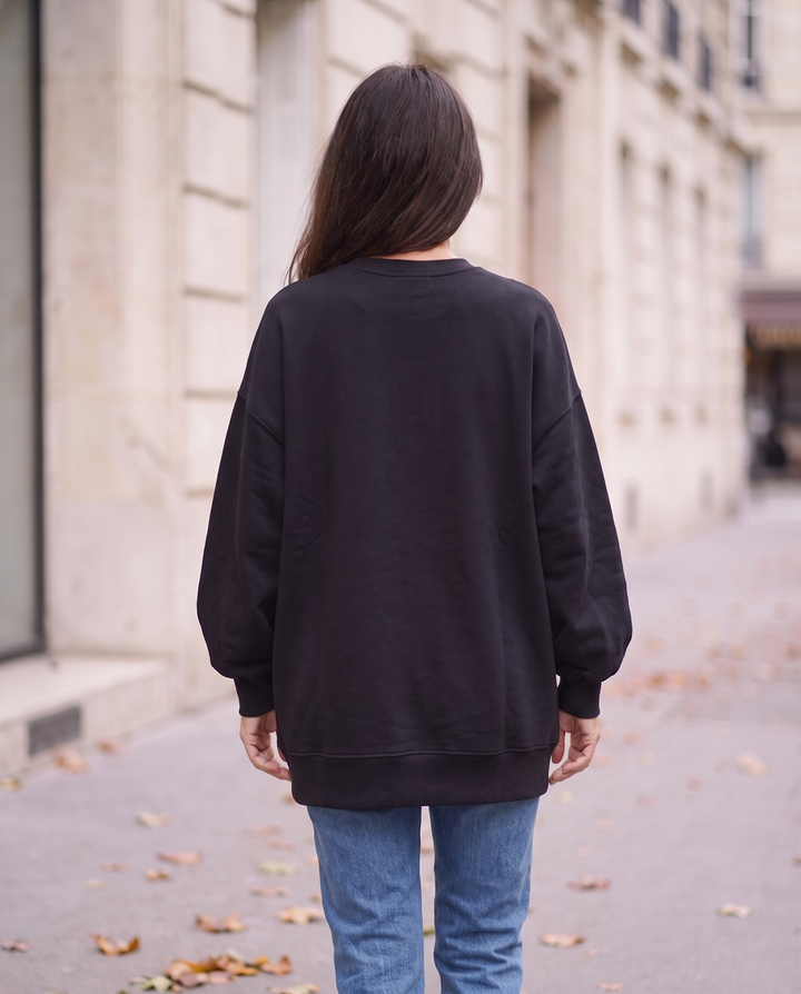 Svart oversized sweatshirt bakifrån med rak obruten nederkant