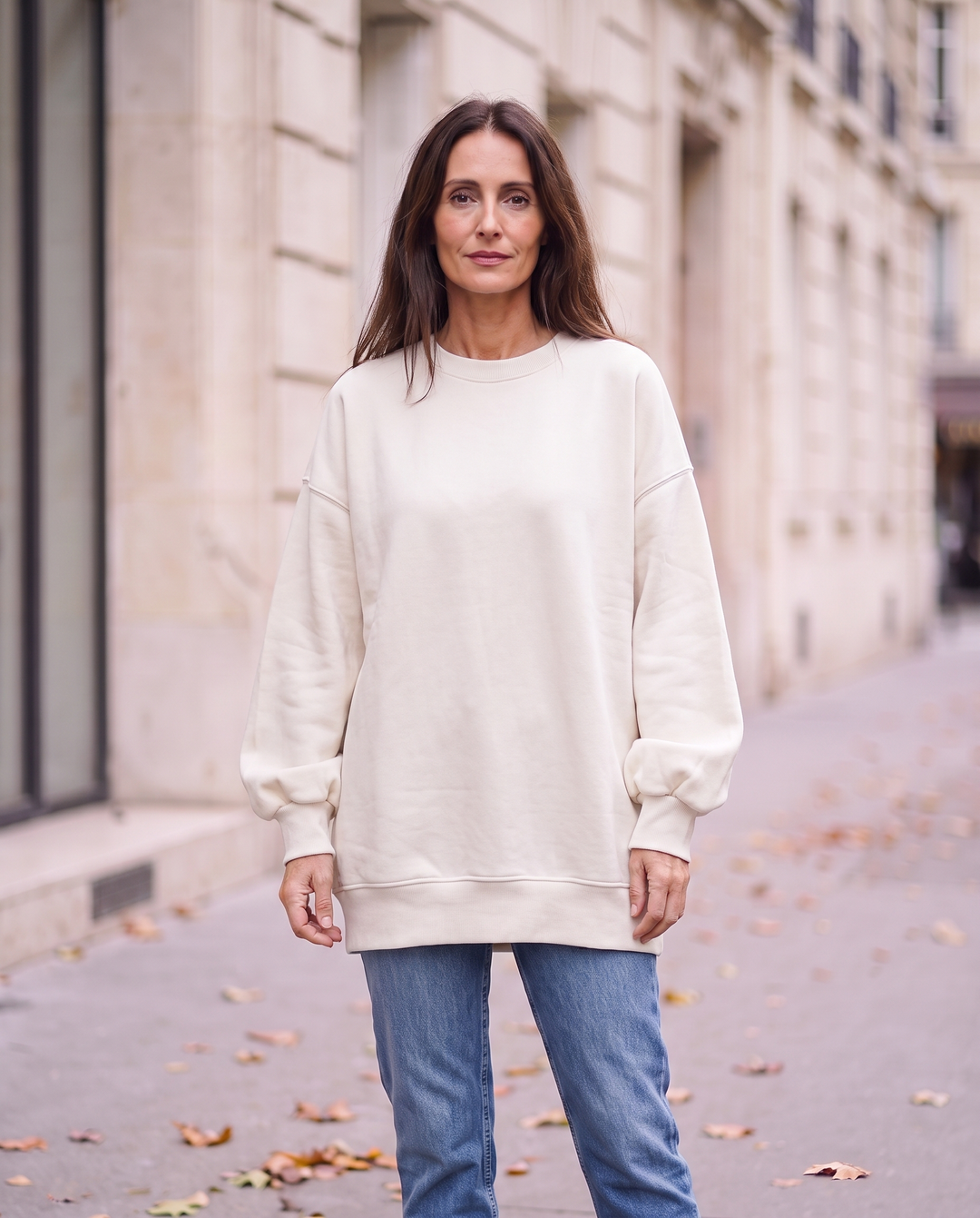 Kvinna i vit oversized sweatshirt utan sidöppningar, framifrån